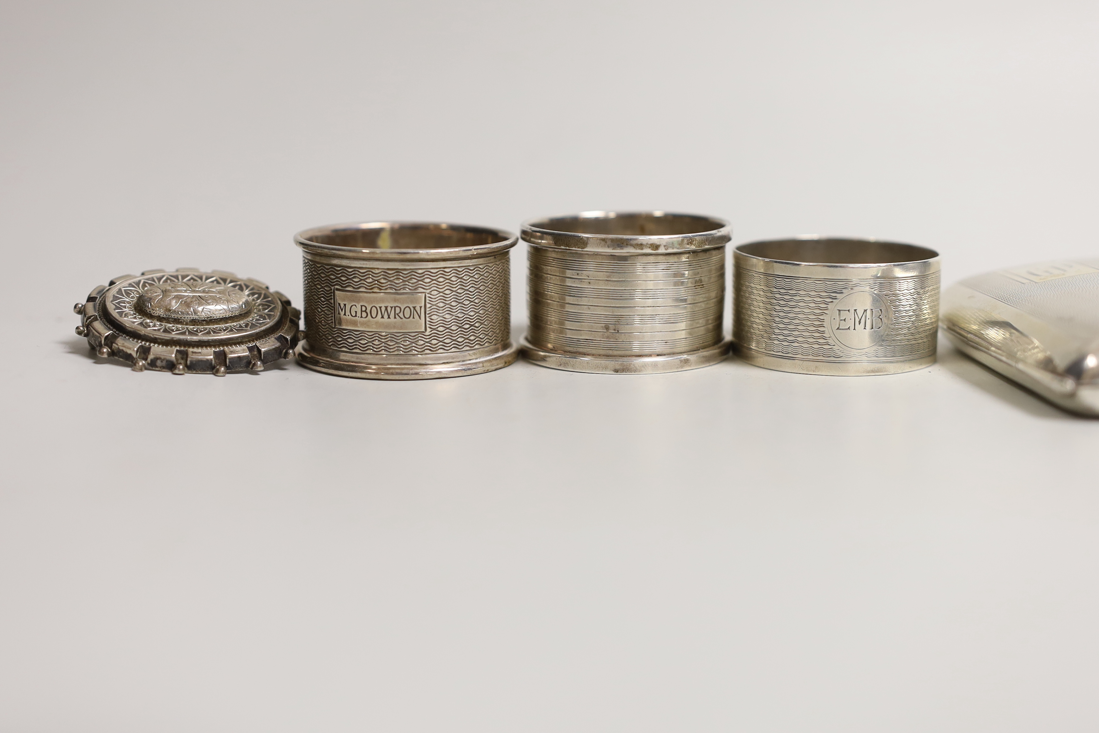 A quantity of mixed silver ware including a cigarette case and enamelled compact (a.f.), a mounted glass inkwell, five napkin rings, (one plated), a brooch and a Fattorini & Sons football pendant.